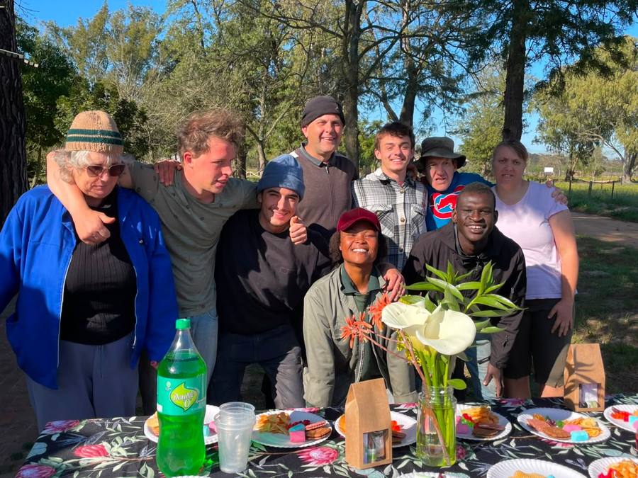 Andy and Stefan with residents and co-workers at their farewell picnic under the trees